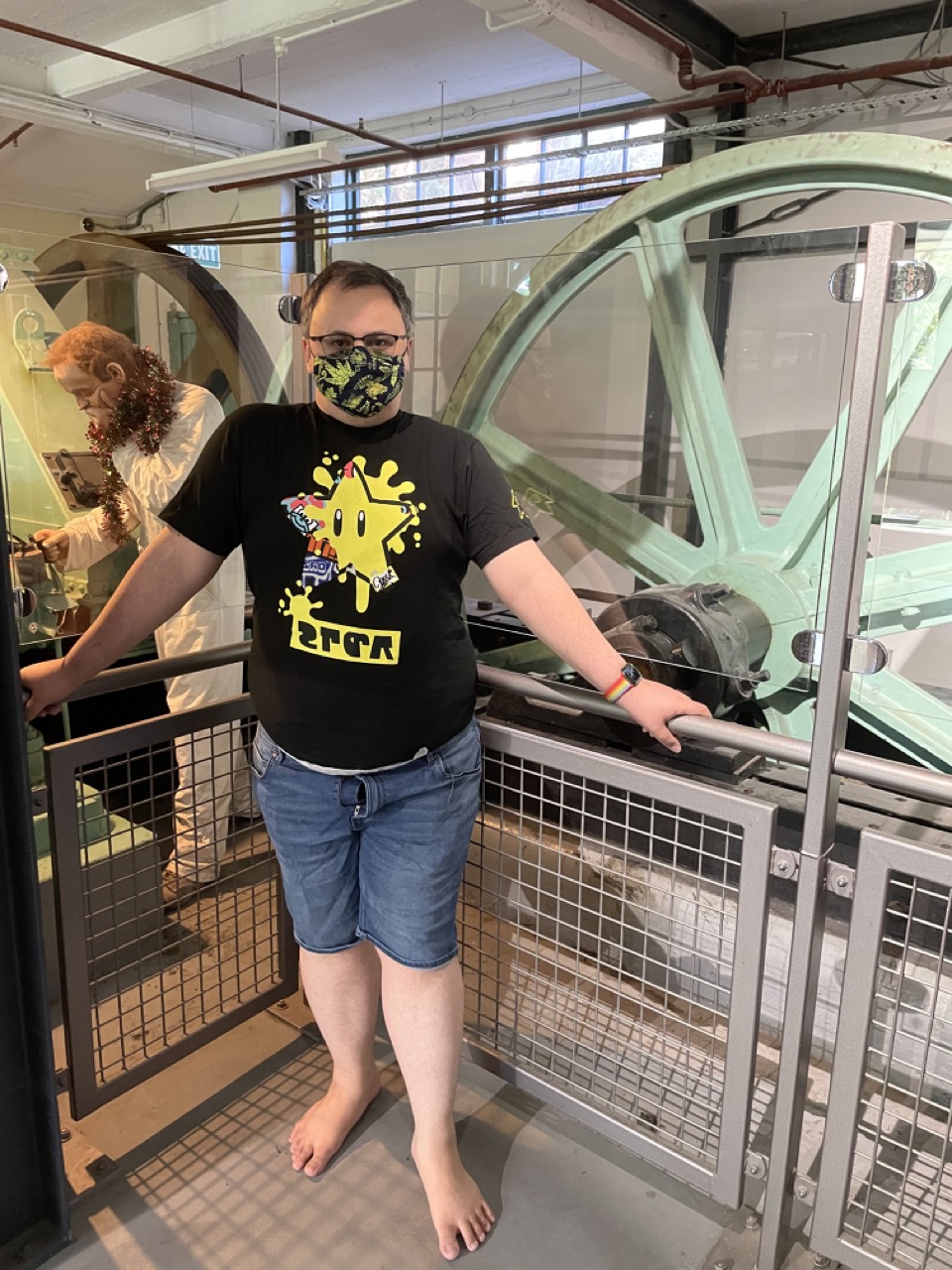 Feets stands in front of the original wheel that pulled the cable car