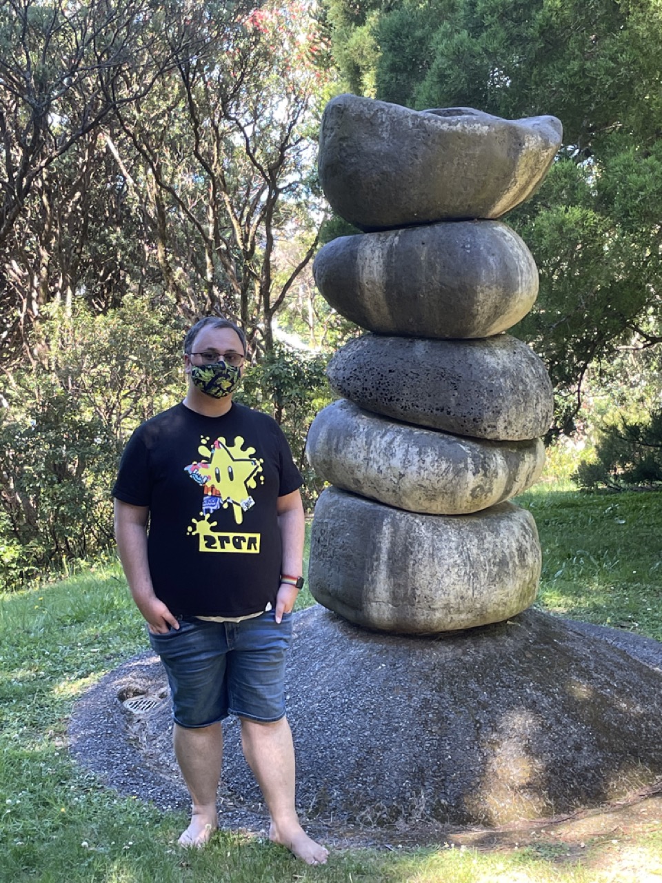 Feets stands next to a stack of large rocks piled on top of each other