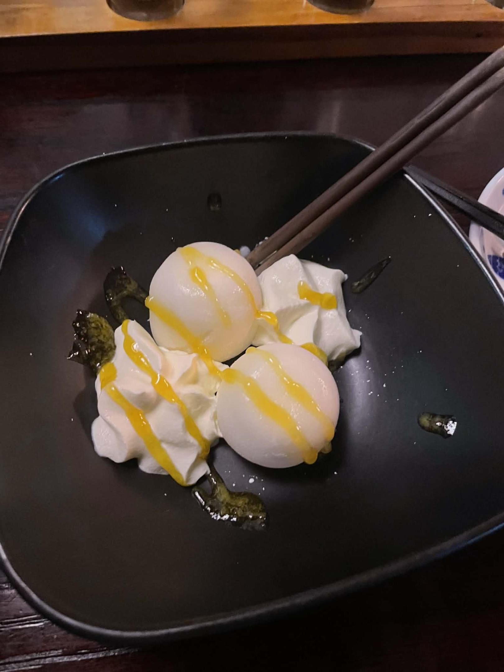 Yukimi daifuku, mochi balls with ice cream inside, with a drizzle of mango sauce.