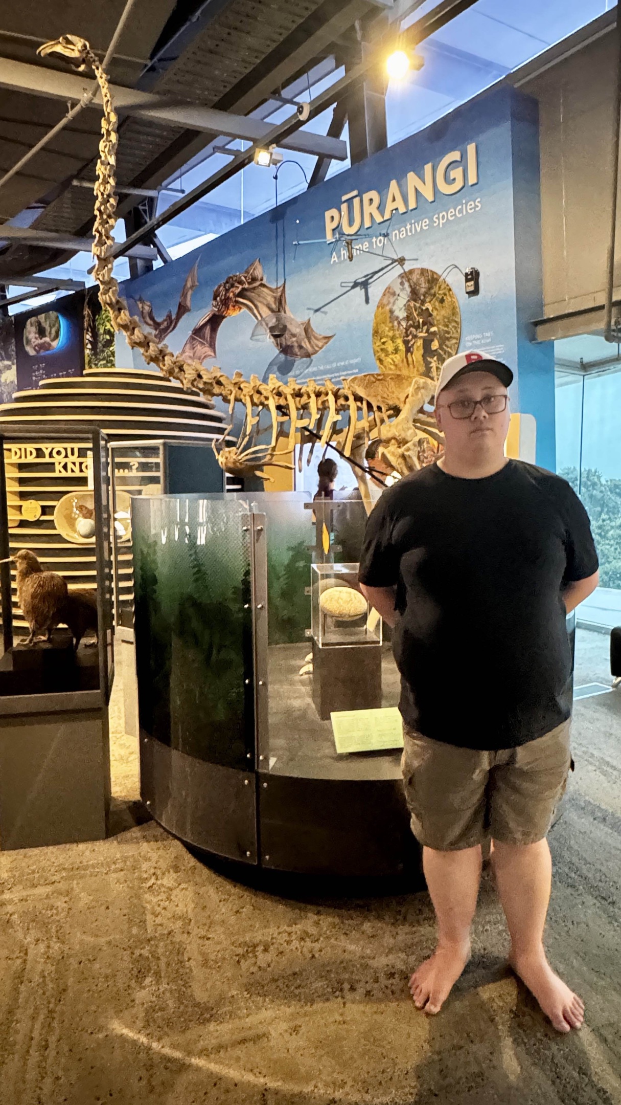 Feets standing in front of a recreation of a Moa skeleton.