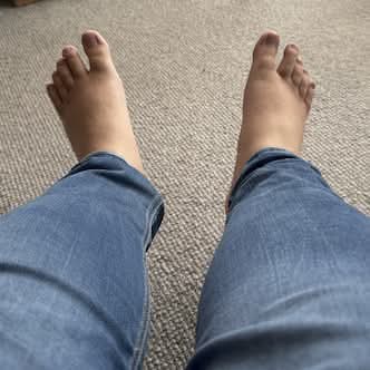 My bare feet at the end of my blue jeans